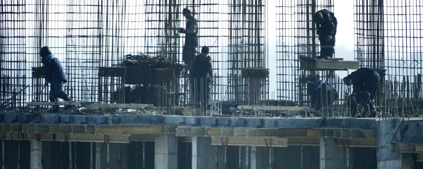 Obreros trabajando sobre la armadura de una estructura de hormigón